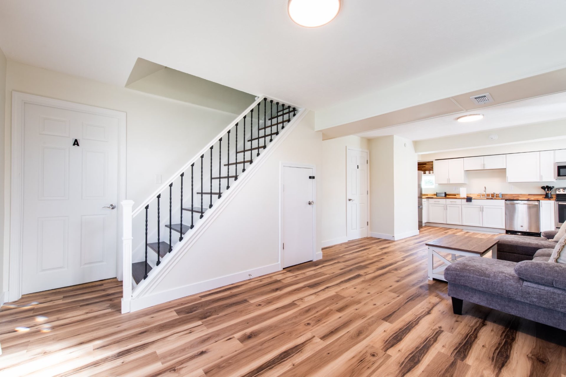 Spacious common area with stairs, living room, and kitchen
